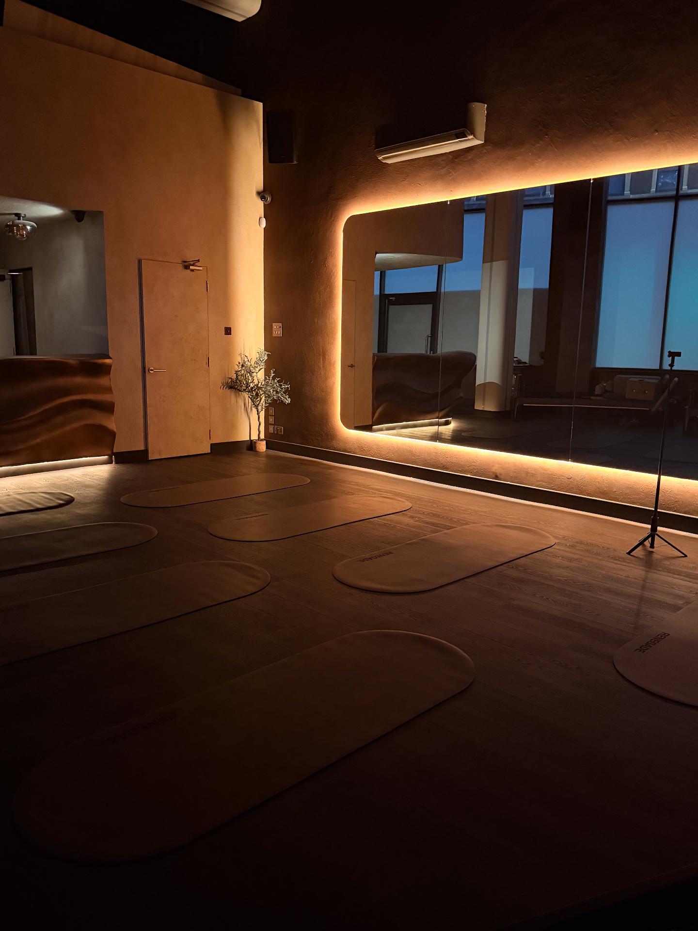 Studio mat area with warm ambient lighting, reformer Pilates Bristol